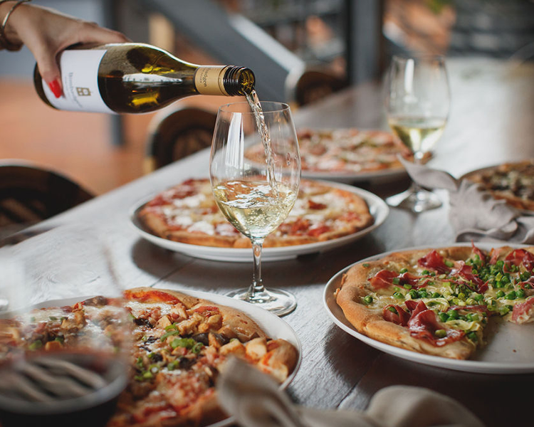 Pizza and wine on the table at Bimbadgen Wood Fire Pizza